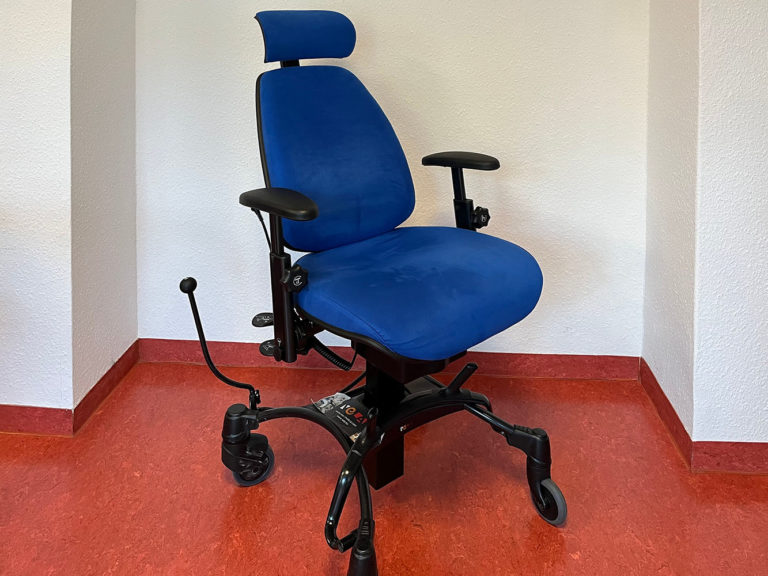 Vela-Stuhl: Rollender, höhenverstellbarer Stuhl mit Kopf- und Armlehnen, mit dem tiefliegende oder hochstehende Gegenstände erreicht werden können, z.B. Spülmaschine oder Teller im Hängeschrank.